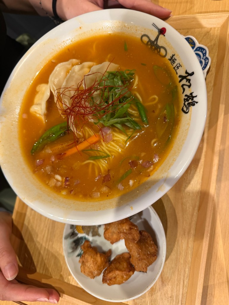 Unsere Ramen in Kyoto, Japan – die Inspiration für das Spicy Miso Ramen Rezept auf Gorgeous Beans. Japanische Ramen-Nudelsuppe mit orange-roter Brühe, Frühlingszwiebeln, Gemüse und Teigtasche in einem Restaurant in Kyoto